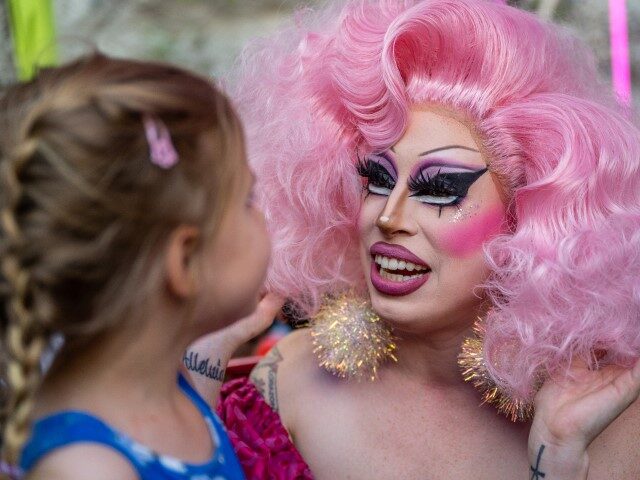 AUSTIN, TEXAS - MARCH 11: Drag Queen Brigitte Bandit speaks with Keanya Philyan, 5, during