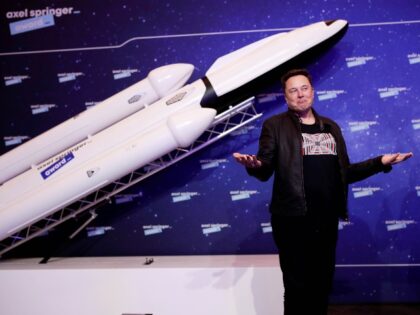 Elon Musk poses with rocket