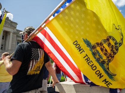 FRANKFORT, KY - AUGUST 28: A man with a Gadsden flag, a US flag, and a Confederate battle