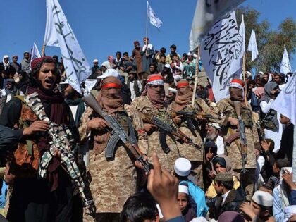 Afghan Taliban militants and villagers attend a gathering as they celebrate the peace deal