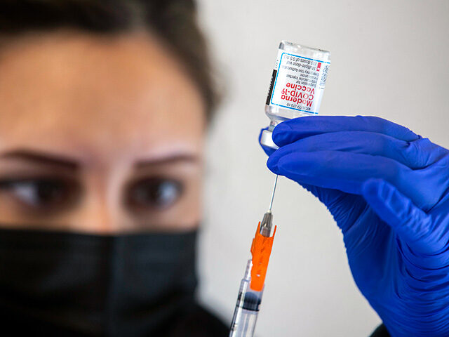 RN Melanie Albor fills a syringe with the Moderna Covid-19 vaccine at an affordable housin