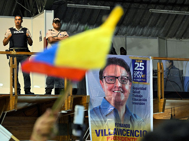 Policemen stand guard while supporters of slain Ecuadorian presidential candidate Fernando