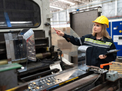Beautiful Caucasian engineer woman working or checking machine at factory