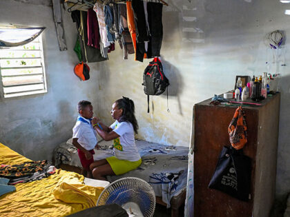 Diana Ruiz takes off her son's school uniform at their home in Havana on March 27, 2024. C