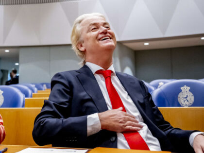 Dutch far-right PVV party leader Geert Wilders (R) reacts ahead of a debate at the House