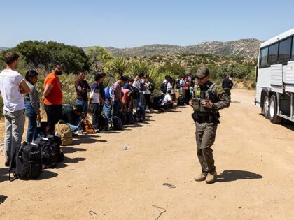 Migrants wait to be processed by the U.S. Border Patrol after crossing the U.S.-Mexico bor