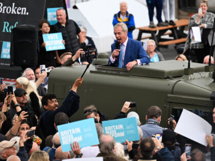 Leader of Reform UK Nigel Farage delivers a speech from the roof of a Land Rover during a