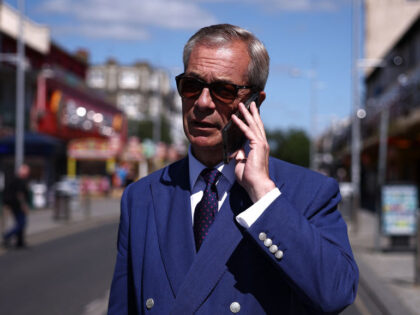 TOPSHOT - Reform UK leader Nigel Farage makes a phone call as he walks in Clacton-on-Sea,