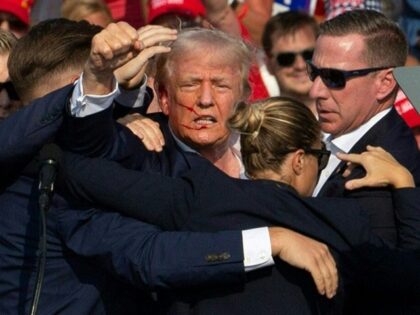 TOPSHOT - Republican candidate Donald Trump is seen with blood on his face surrounded by s