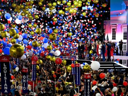 Balloons drop as former US President Donald Trump and his family stand on stage during the