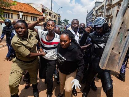 Members of the Uganda Police arrest protesters marching to parliament during a planned ant