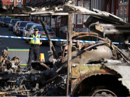 LEEDS, ENGLAND - JULY 19: Police tape cordons off the remains of a burnt out bus after civ