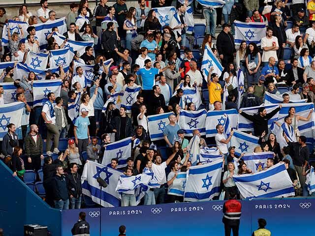 Israel's supporters wave flags in the men's group D football match between Israel and Para