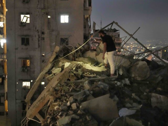 A man inspects a destroyed building that was hit by an Israeli airstrike in the southern s