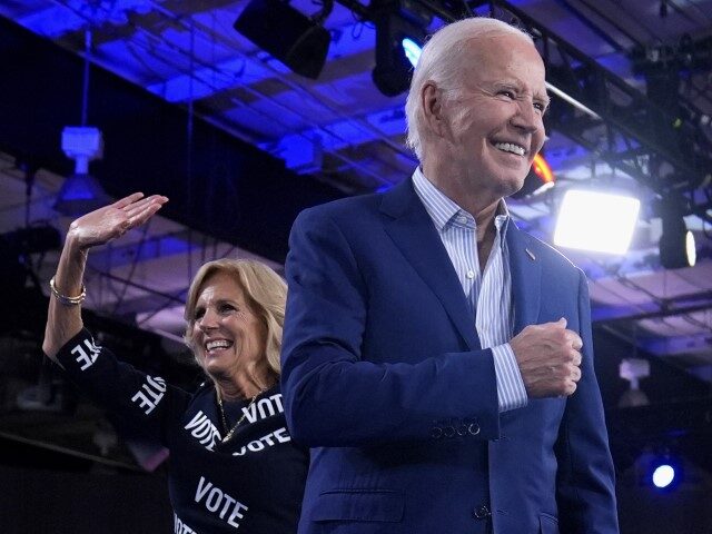 President Joe Biden, right, and first lady Jill Biden walk off stage after speaking at a c