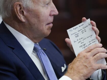 President Joe Biden holds his notes as he listens during a meeting with state and local el