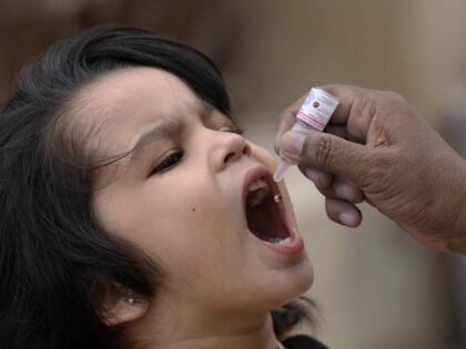 A health worker administers a polio vaccine to a child at a neighbourhood of Karachi, Paki