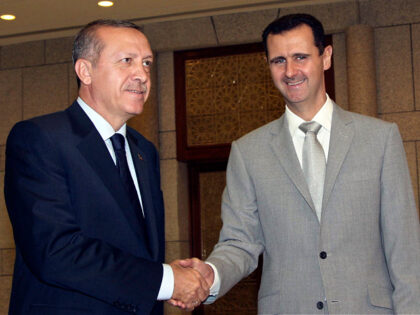 FILE - Syrian President Bashar Assad, right, shakes hands with Turkish Prime Minister Rece