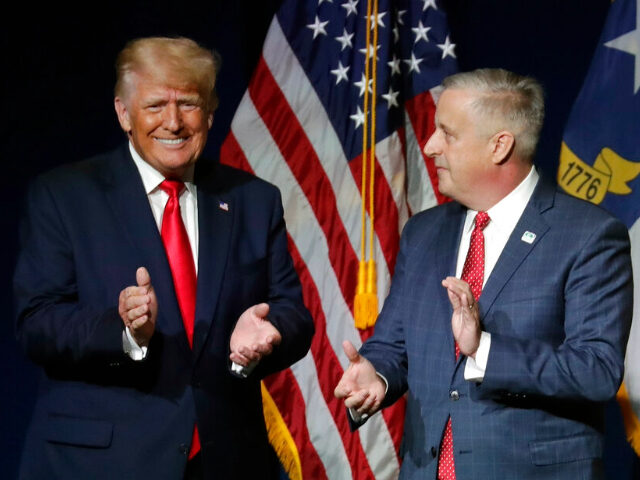 Former President Donald Trump, left, is welcomed by Michael Whatley, …