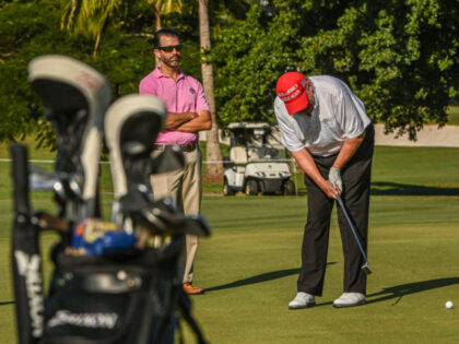 Former US President Donald Trump and his son, Donald Trump, Jr., play golf at Trump Nation