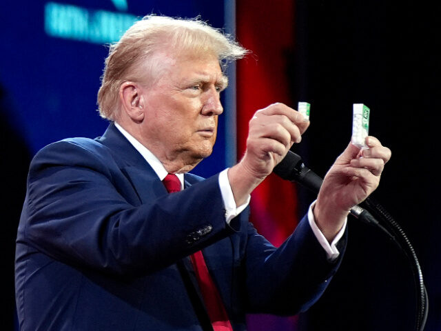 Republican presidential candidate former President Donald Trump holds up Tic Tacs as he di