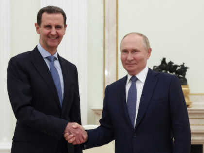 Syrian President Bashar Assad, left, and Russian President Vladimir Putin shake hands duri