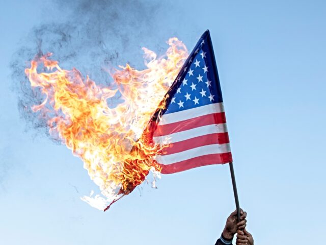 TEHRAN, IRAN - 2023/10/18: Iranian protestors burn a U.S. flag during an anti-Israel rally