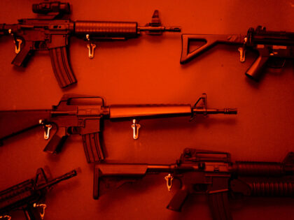 Numerous Assault Rifles Hanging On Wall. - stock photo