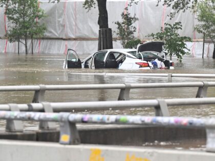 A vehicle is stranded in high waters on a flooded Allen Parkway in Houston, on Monday, Jul