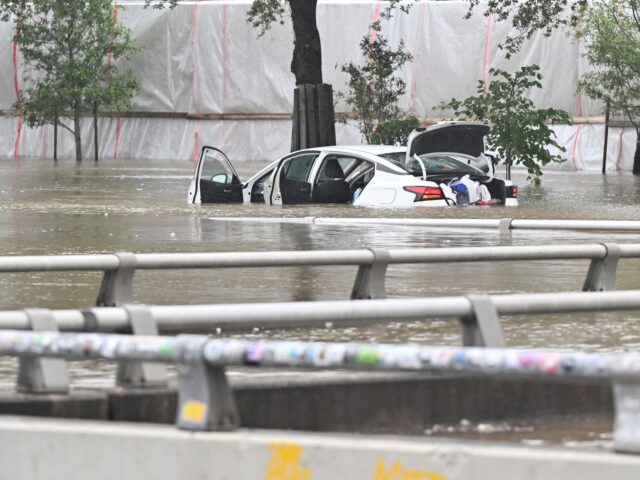 A vehicle is stranded in high waters on a flooded Allen Parkway in Houston, on Monday, Jul