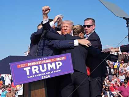 BUTLER, PENNSYLVANIA - July 13: Former president Donald Trump raises his arm with blood on