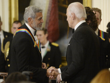 US President Joe Biden, right, greets actor George Clooney during the Kennedy Center honor