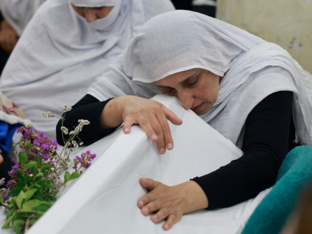 Druze women mourn near the coffin of a loved one after a reported strike from Lebanon fell