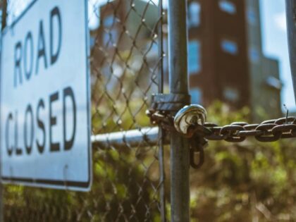 locked gate with road closed sign