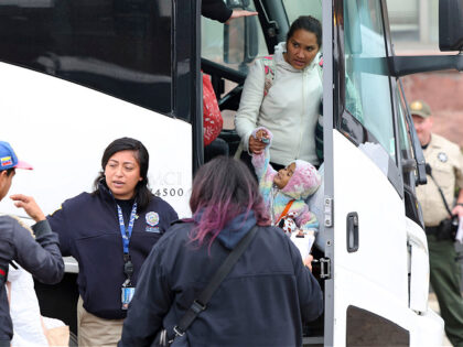 A group of migrants arrive by bus near a Greyhound station in Chicago after being transpor