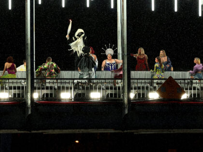 PARIS, FRANCE - JULY 26: Mysterious Torchbearer holds the Olympic Torch while on a bridge