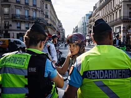 French Gendarmerie officers check pedestrians and cyclists QR codes and luggages at a barr