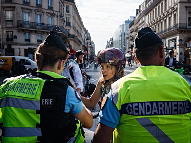 French Gendarmerie officers check pedestrians and cyclists QR codes and luggages at a barr