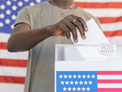 Person Putting his Vote on Ballot Box