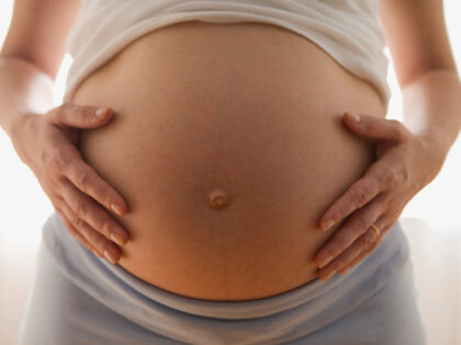 Close up of pregnant woman's belly - stock photo
