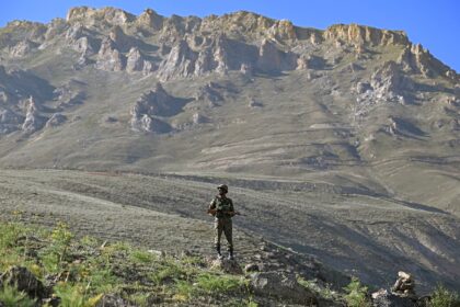 An Indian army soldier stands guard on Lamochan mountain overlooking Kargil district, site