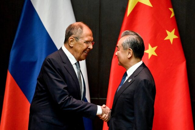 China's Foreign Minister Wang Yi (R) shakes hands with Russia's Foreign Minister Sergei La