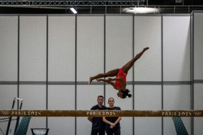 Coaches Laurent and Cecile Landi watch as superstar US gymnast Simone Biles trains at the