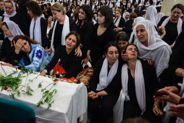 Druze women mourn by a coffin during a funeral after a rocket strike from Lebanon which, I