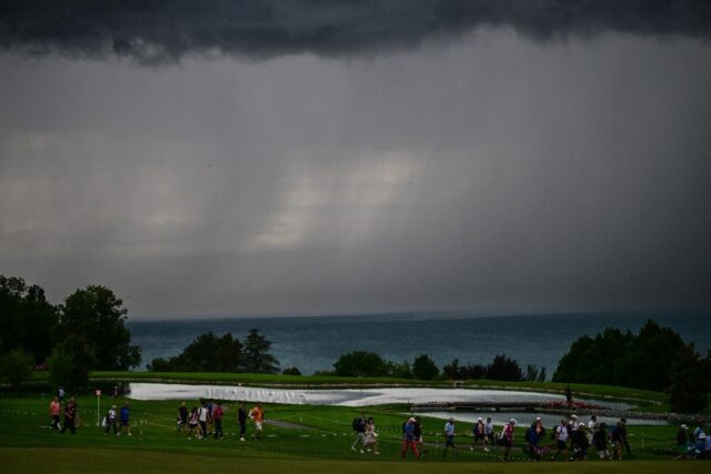 Golfers leave the golf course during the second round of the Evian Championship due to bad