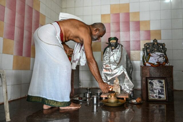 Hindu priest Subhramanya Sharma lights a lamp while praying for the victory of US vice pre