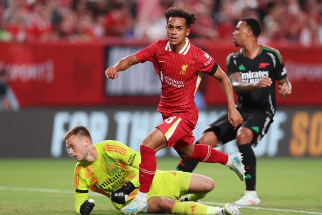 Liverpool midfielder Fabio Carvalho, center, scores past Arsenal goalkeeper Karl Hein in a