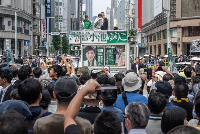 Polls suggest Tokyo governor Yuriko Koike (C at a campaign rally Saturday) will win a thir