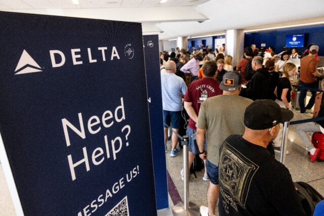 Travelers wait in line at the airport in Los Angeles, California on July 19, 2024 followin