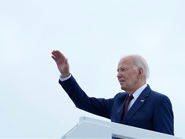 President Joe Biden waves from the top of the steps of Air Force One at Joint Base Andrews